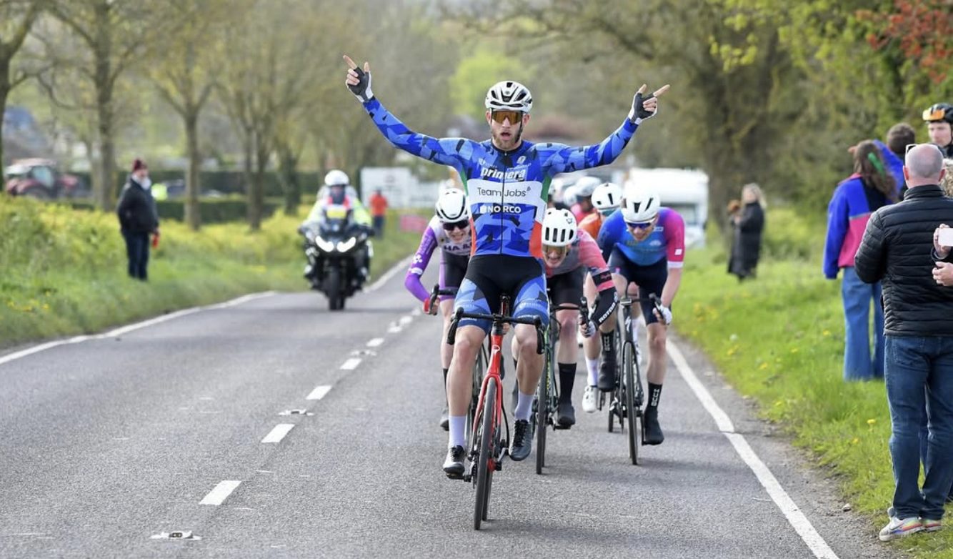 A 2EZ athlete winning a road race with arms raised
